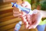 Bottle of hand sanitizer in woman's hands